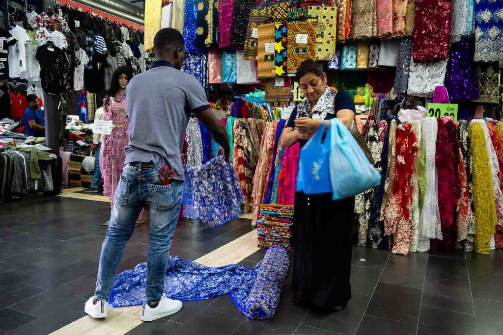 una donna indiana compra delle stoffe al Mercato Esquilino